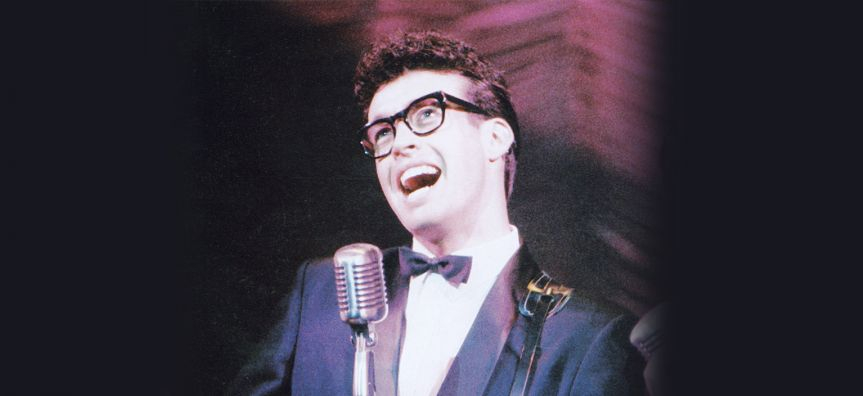 buddy holly signing behind a microphone