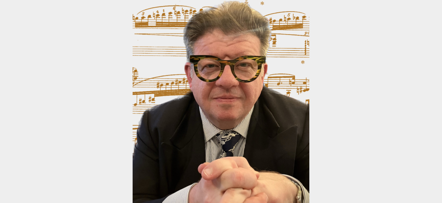 Musician Glenn Amer stares into the camera with a smile. He is wearing a suit and tie and fabulous tortoishell glasses against a backdrop of music notes.