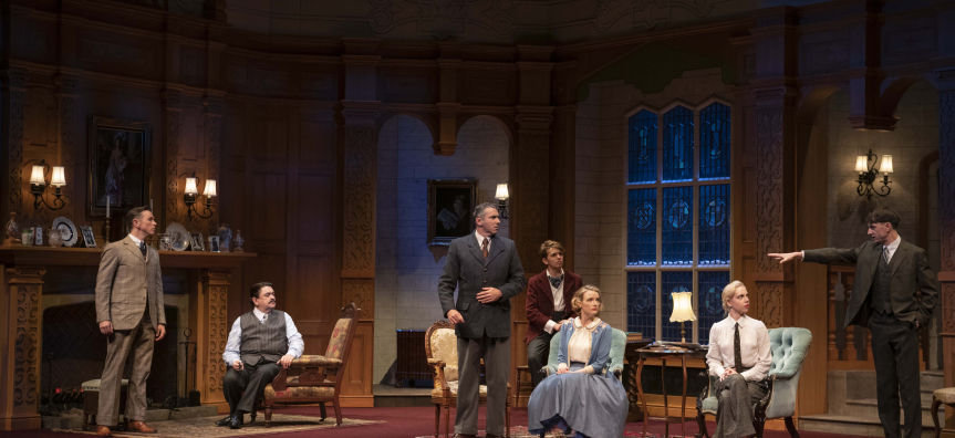 The 2022 Australian Cast of THE MOUSETRAP stand on stage - a man on the far right points his finger at another man on the far left of the stage in accusation