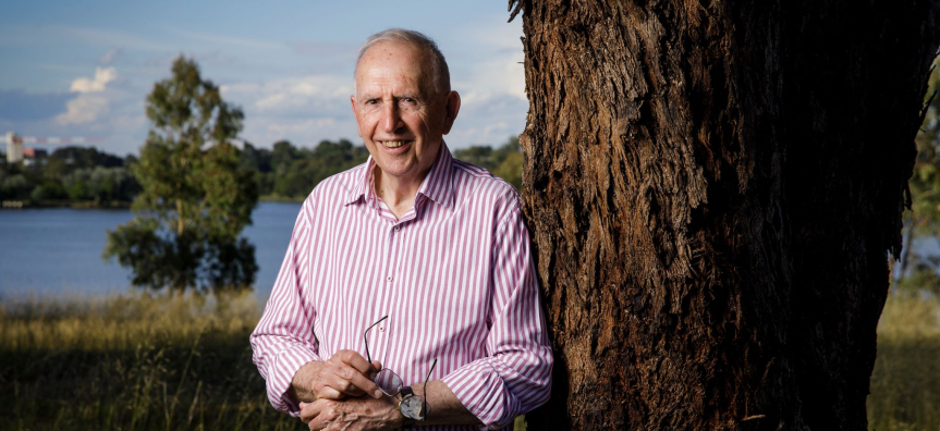 Hugh Mackay standing by a tree