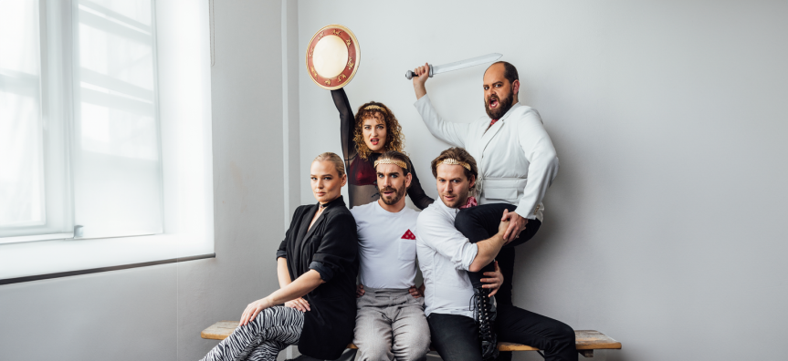 Four performers strike war like poses, holding shields and swords