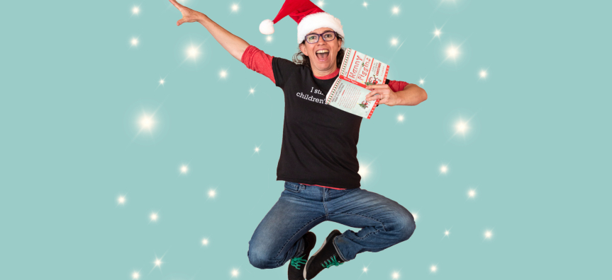 A person in a santa hat holding a book and jumping in the air