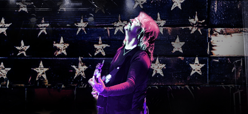 Bob plays the guitar in front of a starry background