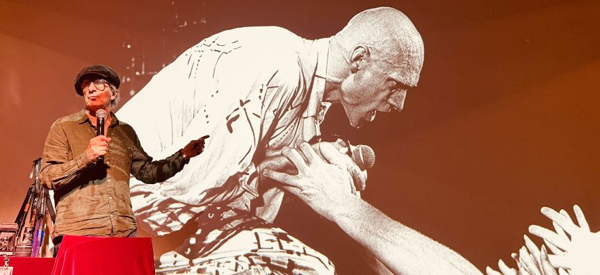 Tony Mott on stage talking about his photograph of Peter Garrett